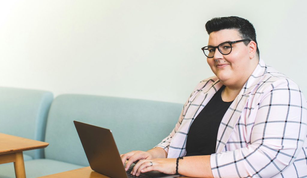 woman in checkered jacket sitting at desk working